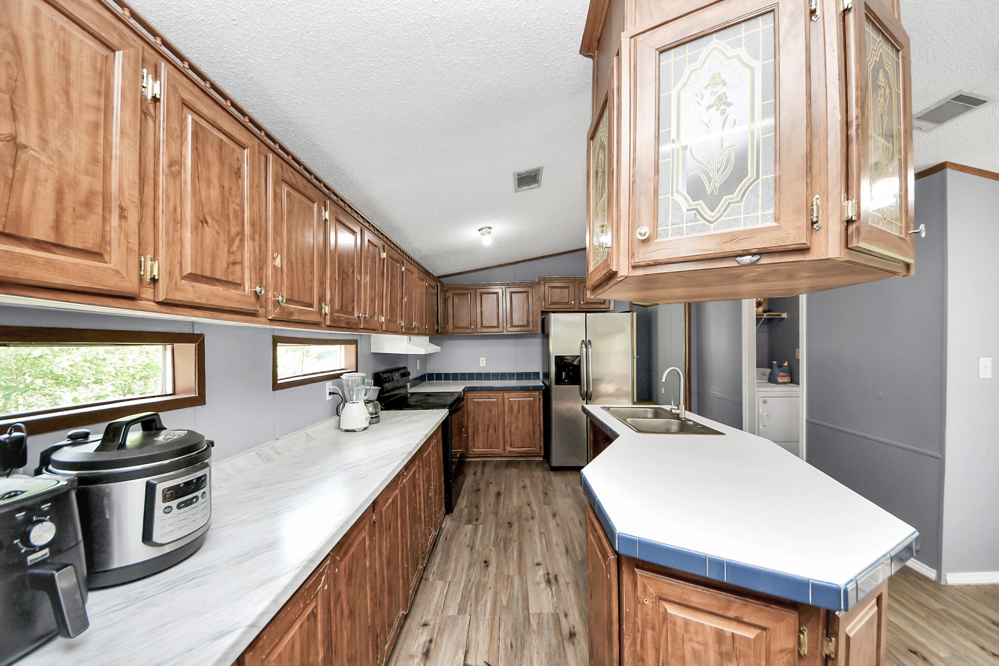 25932 Thatcham New Caney, TX 77357 - Photo 10 of 44 a kitchen with stainless steel appliances granite countertop a stove top oven a refrigerator a sink and dishwasher with wooden floor