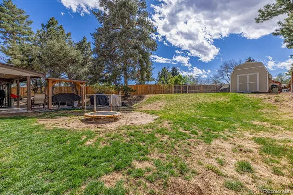 a backyard of a house with table and chairs and a fire pit