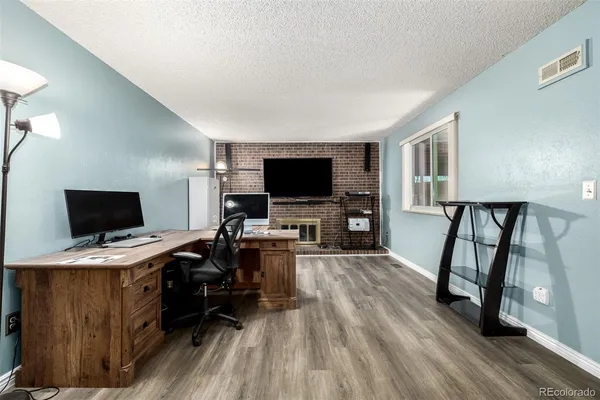 a view of a livingroom with workspace and a flat screen tv