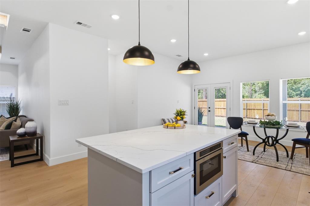 435 Waterboard Road Trinidad, TX 75163 - Photo 10 of 39 Modern kitchen island featuring a light-toned countertop, under-counter microwave, and pendant lighting