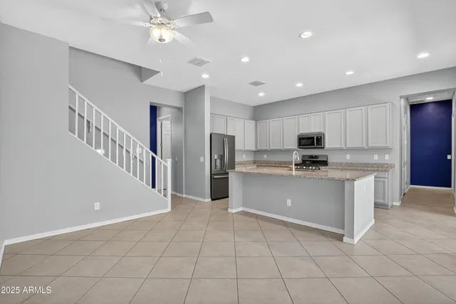 a kitchen with stainless steel appliances granite countertop a sink dishwasher stove top oven and refrigerator