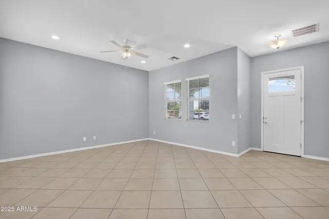 an empty room with windows and fan