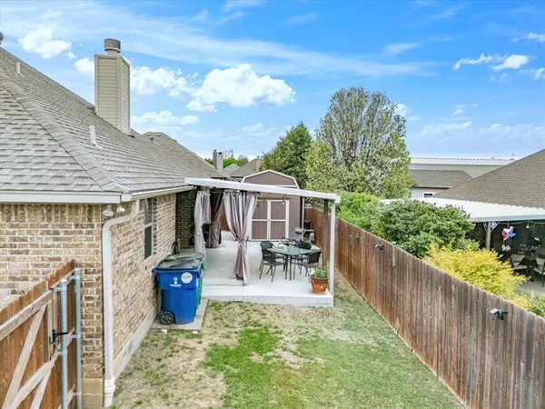 a view of a patio with table and chairs potted plants with wooden fence