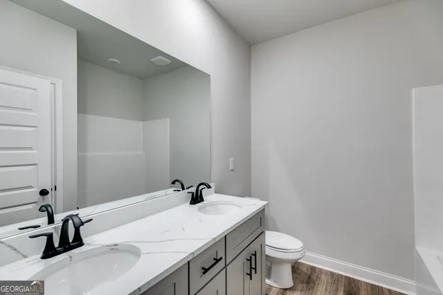 a bathroom with a sink a toilet and a mirror