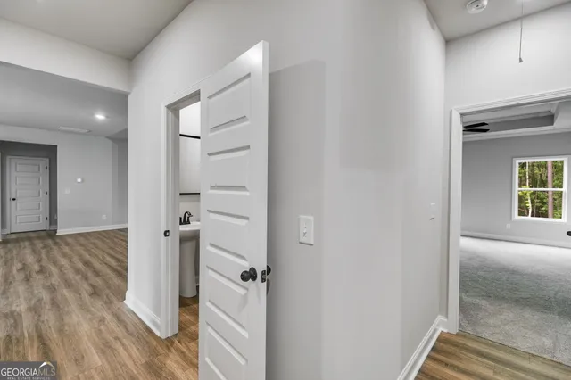 a view of a hallway with wooden floor and closet area