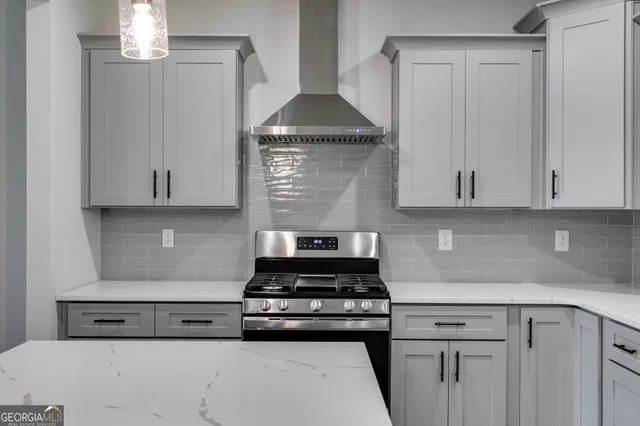 a kitchen with granite countertop white cabinets and white stove