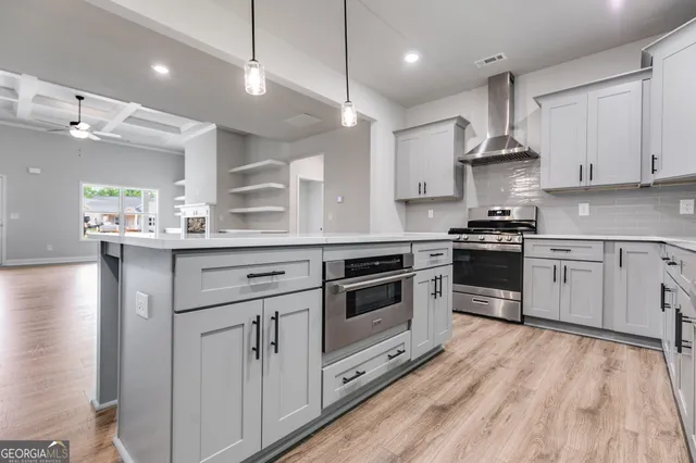 a kitchen with stainless steel appliances white cabinets and wooden floors