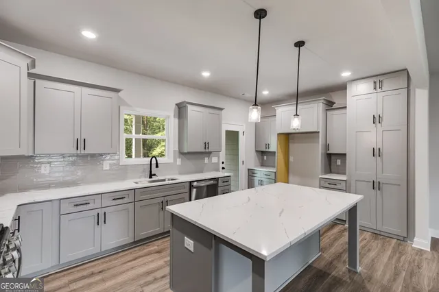 a kitchen with a sink a center island a counter space and a refrigerator