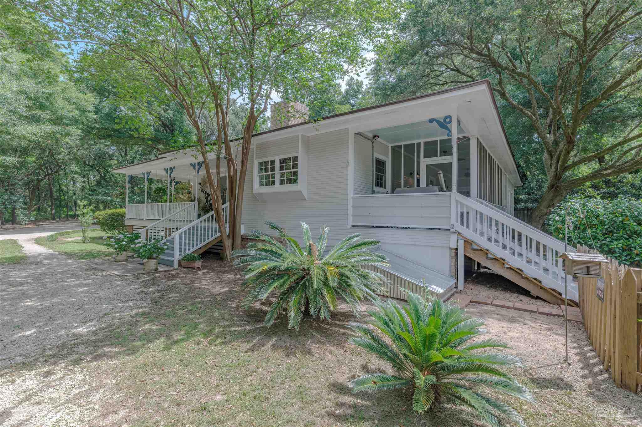 5049 Guernsey Road Pace, FL 32571 - Photo 50 of 61 a view of a house with a house and a yard with wooden fence