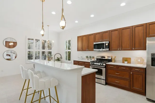 a kitchen with stainless steel appliances a stove a sink a refrigerator and cabinets