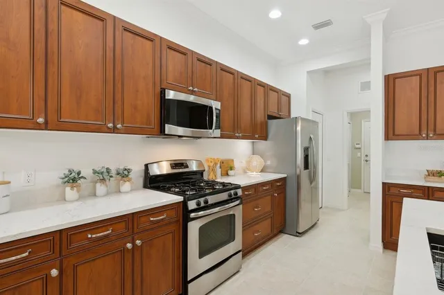 a dining room filled chandelier and kitchen view