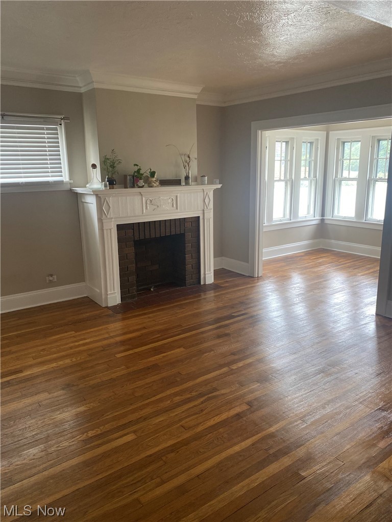 4688 Rockwood Road Cleveland, OH 44125 - Photo 14 of 35 Hardwood floored living room featuring ornamental molding, a fireplace, and a textured ceiling