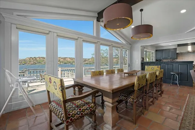 a view of a dining room with furniture and large windows