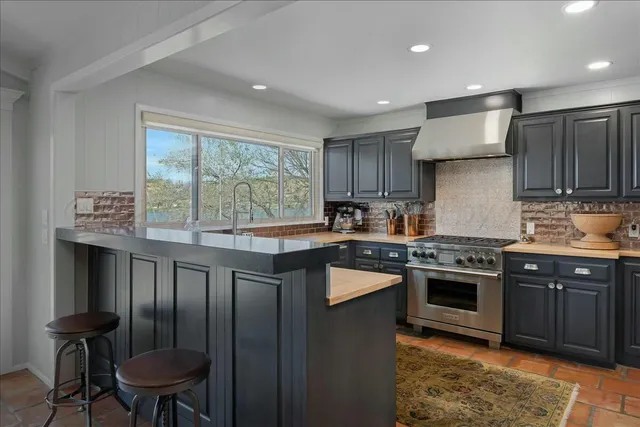 a kitchen with a sink stove top oven and cabinets