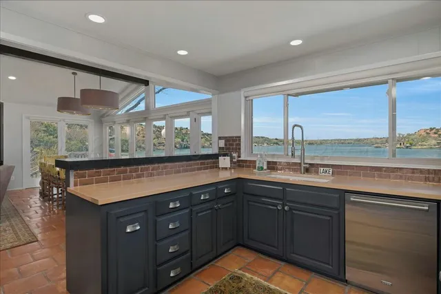 a kitchen with granite countertop a stove top oven cabinetry a sink and dishwasher