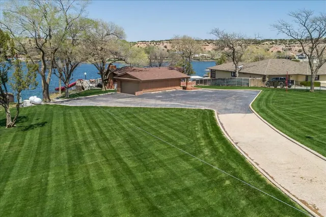 an aerial view of a house with a garden and lake view