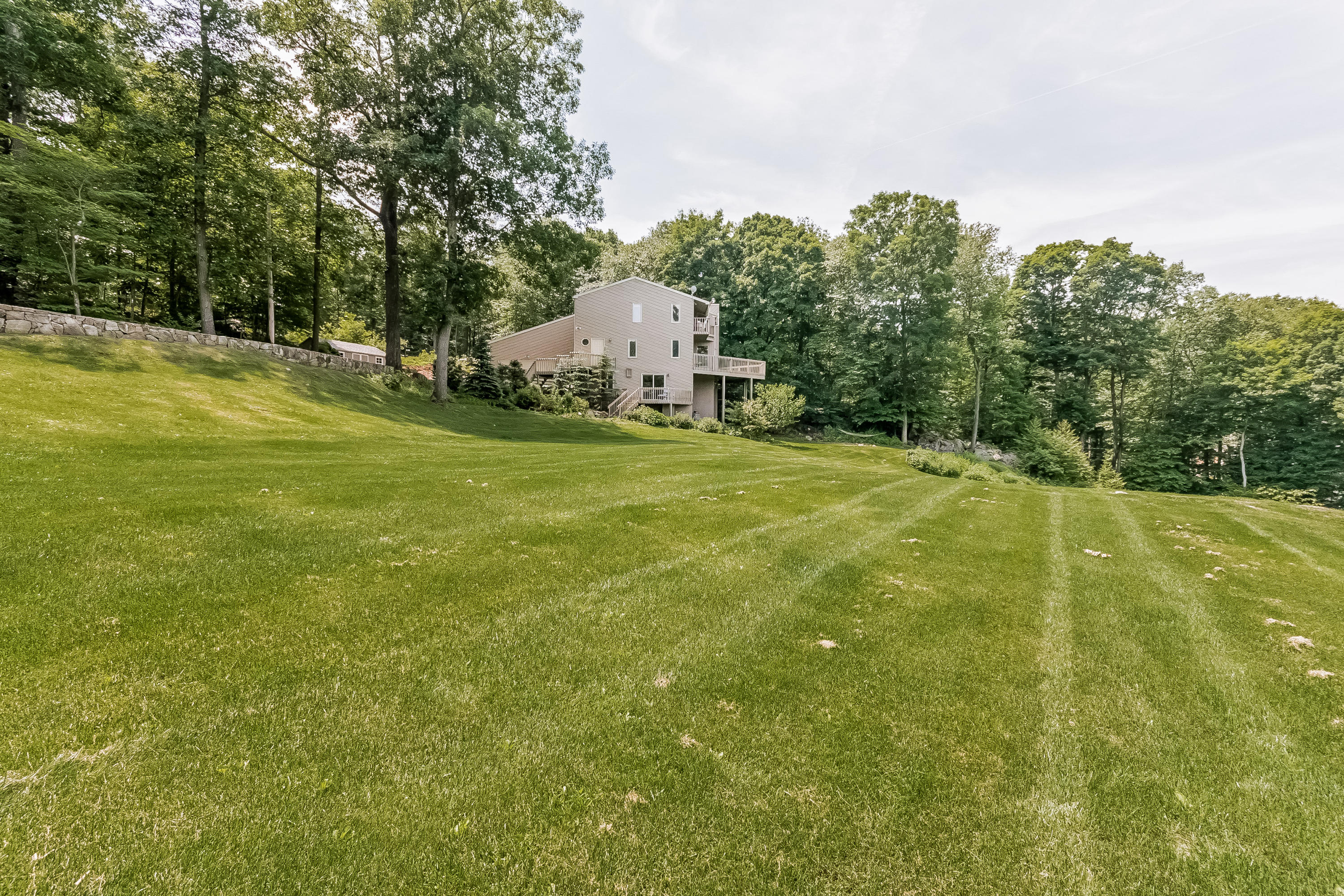 17 Bayberry Hill Road Ridgefield, CT 06877 - Photo 48 of 50 a view of a big yard with swimming pool and trees in the background