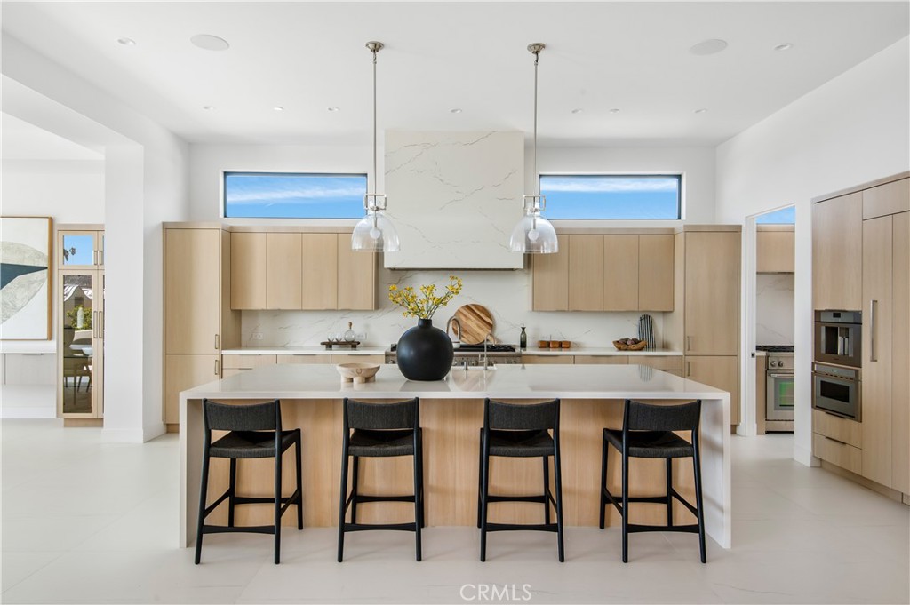 11 Seabreeze Terrace Dana Point, CA 92629 - Photo 9 of 46 a kitchen with stainless steel appliances kitchen island granite countertop a table chairs sink refrigerator and microwave