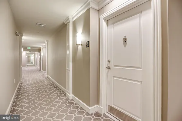 a view of a hallway with wooden floor and closet