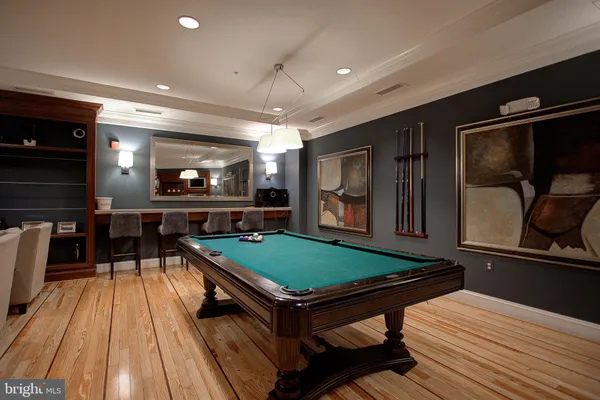 a room with furniture pool table flat screen tv and windows