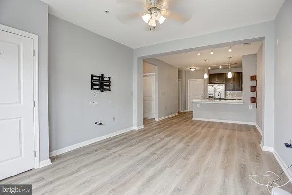 an empty room with kitchen and windows