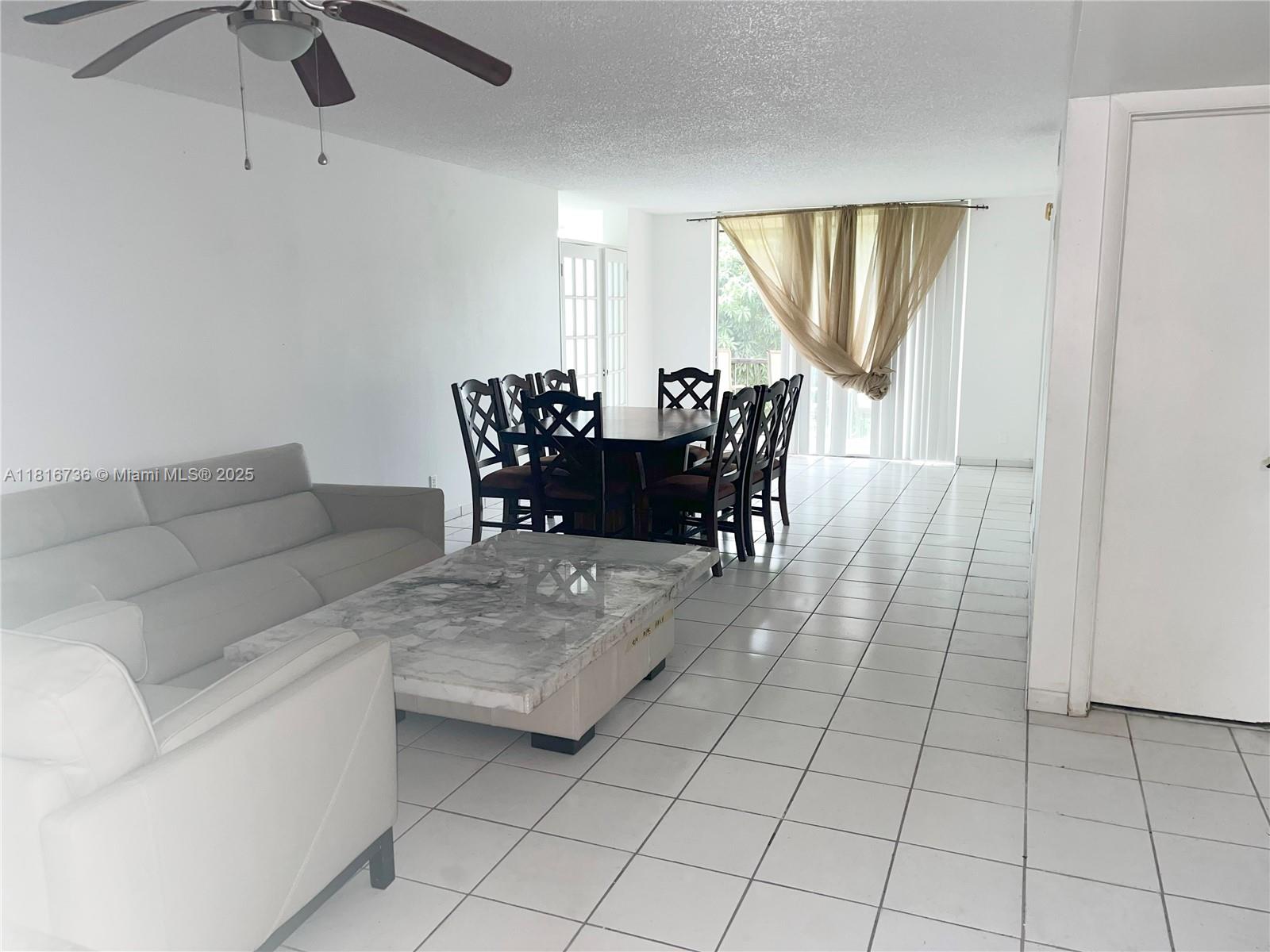 9820 South Hollybrook Lake Drive, Unit 205 Pembroke Pines, FL 33025 - Photo 3 of 4 a living room with furniture and a chandelier