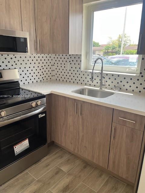 1151 West 28th Street, Unit 1 Hialeah, FL 33010 - Photo 3 of 25 a kitchen with granite countertop a stove a sink and a microwave