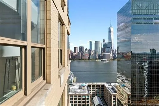 a kitchen with stainless steel appliances granite countertop a sink a stove top oven a dining table and chairs with wooden floor