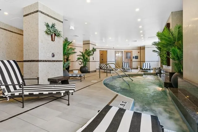 a room with stainless steel appliances kitchen island granite countertop cabinets and wooden floor
