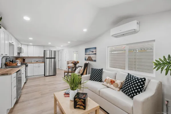 a living room with furniture kitchen and a large window