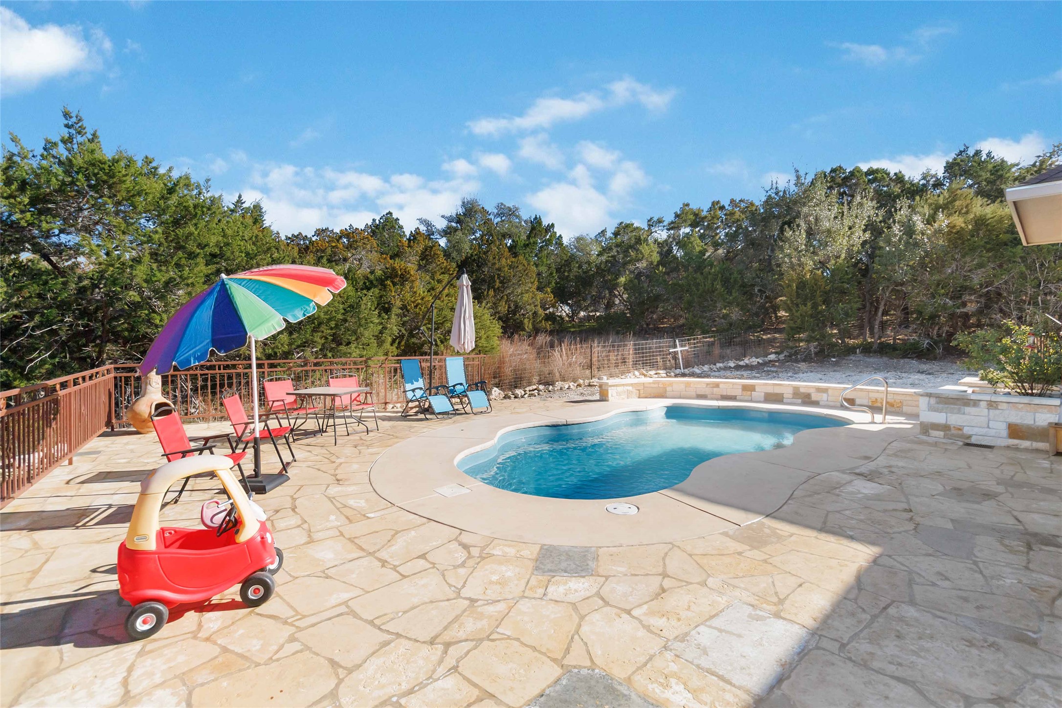 1193 Persimmon Pass Fischer, TX 78623 - Photo 22 of 27 View of saltwater swimming pool with a stone patio area and wooded view