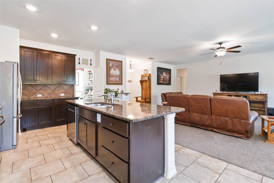 1193 Persimmon Pass Fischer, TX 78623 - Photo 9 of 27 Kitchen with a kitchen breakfast bar, dark brown cabinets, stainless steel appliances