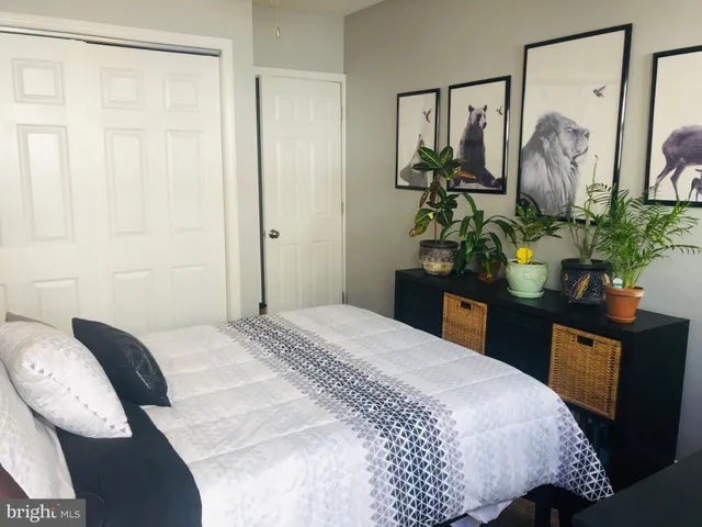 a bedroom with a bed potted plant with the mirror