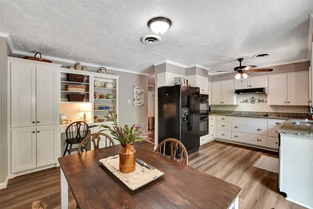 a kitchen with sink refrigerator dining table and chairs