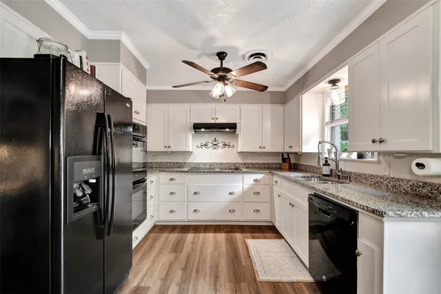 a kitchen with granite countertop a refrigerator oven a sink and dishwasher