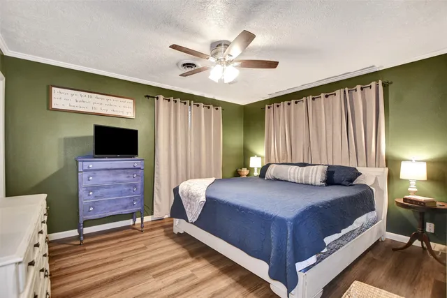 a bedroom with a bed a flat screen tv and dresser
