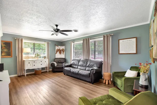a living room with furniture and three windows