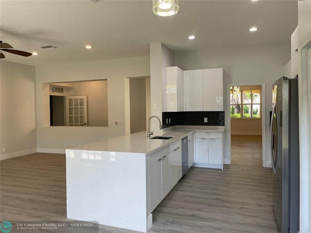 4293 Laurel Ridge Circle Weston, FL 33331 - Photo 20 of 63 a kitchen with granite countertop white cabinets and stainless steel appliances