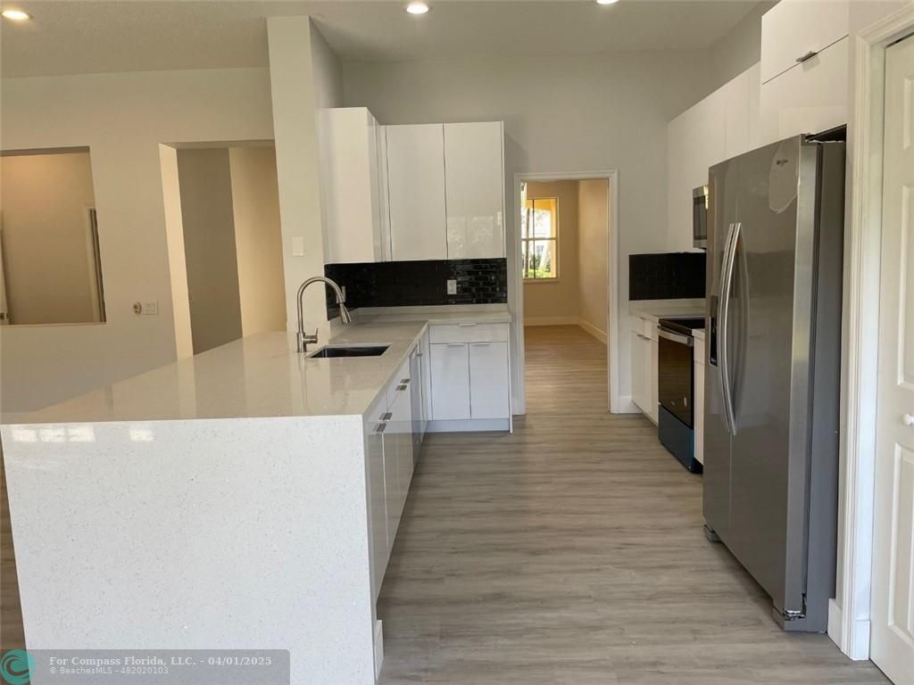 4293 Laurel Ridge Circle Weston, FL 33331 - Photo 21 of 63 a kitchen with a refrigerator and a stove top oven