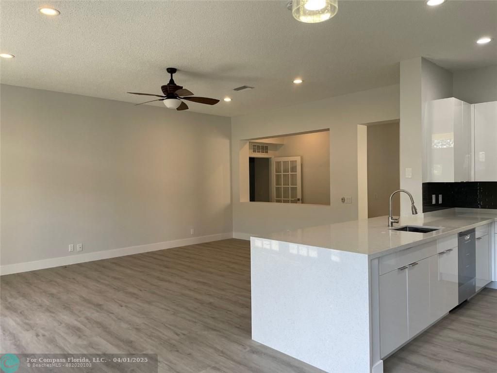 4293 Laurel Ridge Circle Weston, FL 33331 - Photo 22 of 63 a view of a kitchen with a sink a ceiling fan and wooden floor