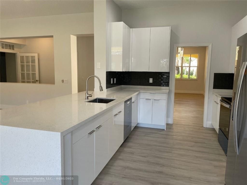 4293 Laurel Ridge Circle Weston, FL 33331 - Photo 23 of 63 a kitchen with a sink cabinets and wooden floor