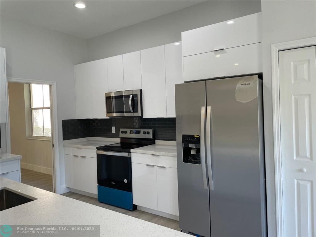 4293 Laurel Ridge Circle Weston, FL 33331 - Photo 24 of 63 a kitchen with a refrigerator a microwave a sink and cabinets