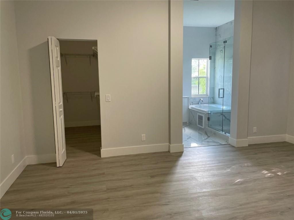 4293 Laurel Ridge Circle Weston, FL 33331 - Photo 31 of 63 a view of a hallway with wooden floor and a bathroom