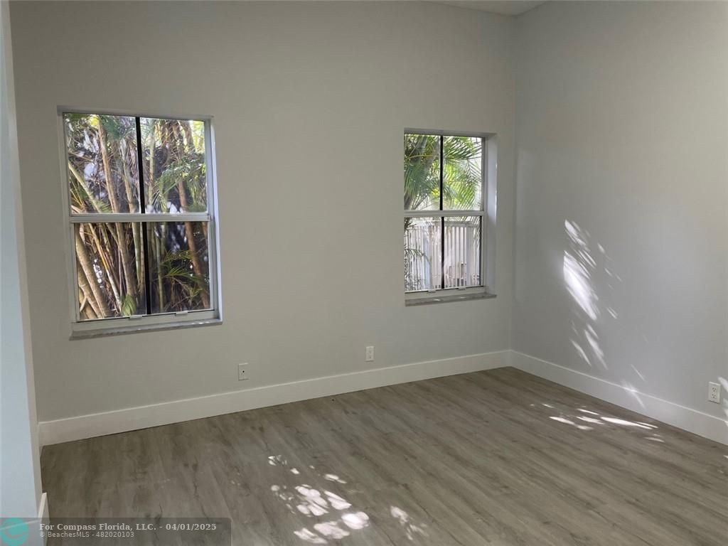 4293 Laurel Ridge Circle Weston, FL 33331 - Photo 44 of 63 a view of an empty room with wooden floor and a window