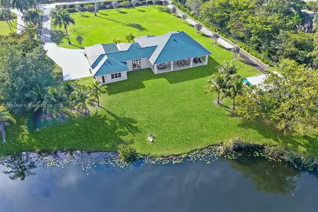 an aerial view of a house with a yard and lake view