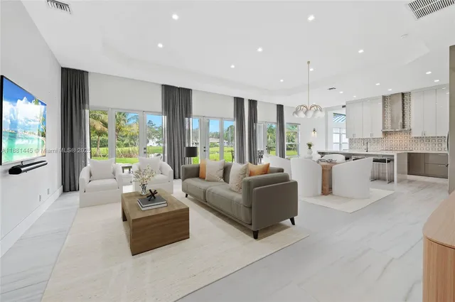 a view of an empty room with wooden floor and windows