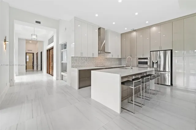 a large kitchen with kitchen island a sink stainless steel appliances and cabinets