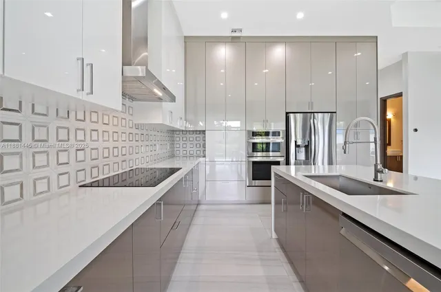 a large kitchen with kitchen island white cabinets and stainless steel appliances