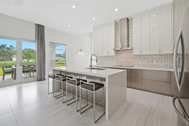 a kitchen with stainless steel appliances kitchen island sink refrigerator and cabinets