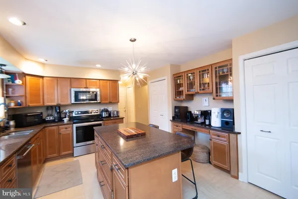 a kitchen with a refrigerator a stove top oven a sink dishwasher and white cabinets with wooden floor